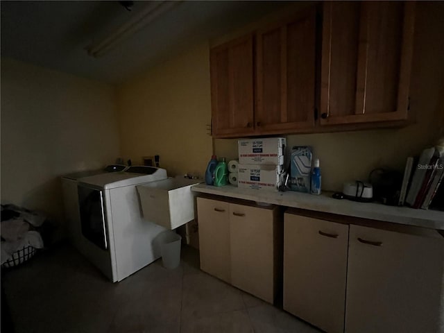 washroom featuring sink, light tile patterned flooring, cabinets, and washer / dryer