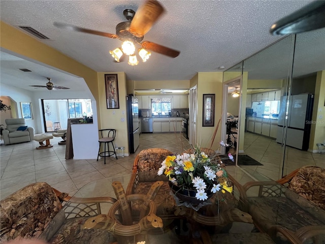 living room featuring a textured ceiling, a wealth of natural light, and ceiling fan