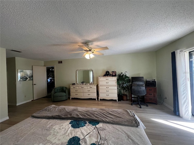 bedroom featuring wood-type flooring, a textured ceiling, and ceiling fan