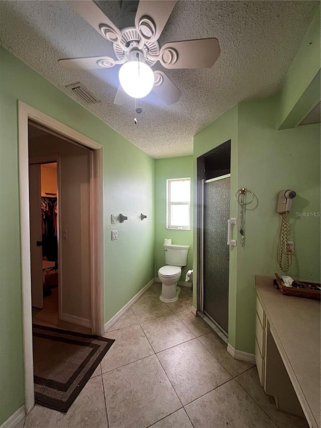 bathroom featuring tile patterned flooring, ceiling fan, a textured ceiling, and walk in shower