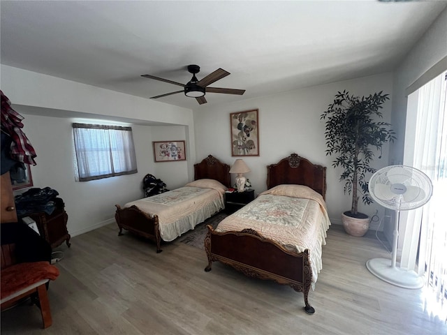 bedroom with light hardwood / wood-style flooring, multiple windows, and ceiling fan