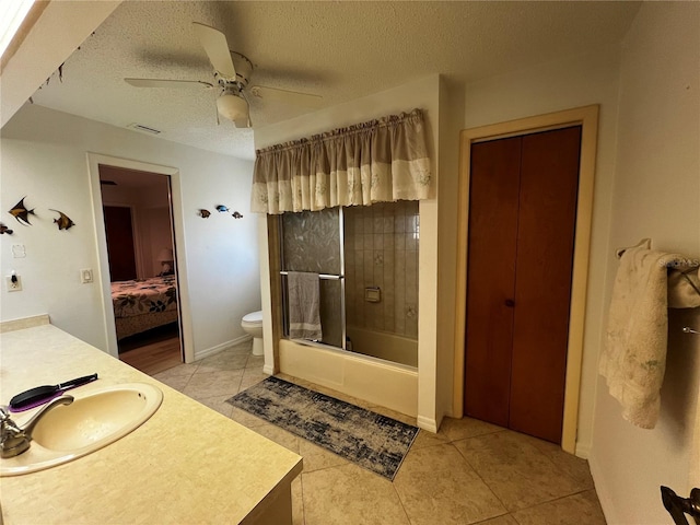 full bathroom featuring tile patterned floors, a textured ceiling, bathing tub / shower combination, ceiling fan, and toilet