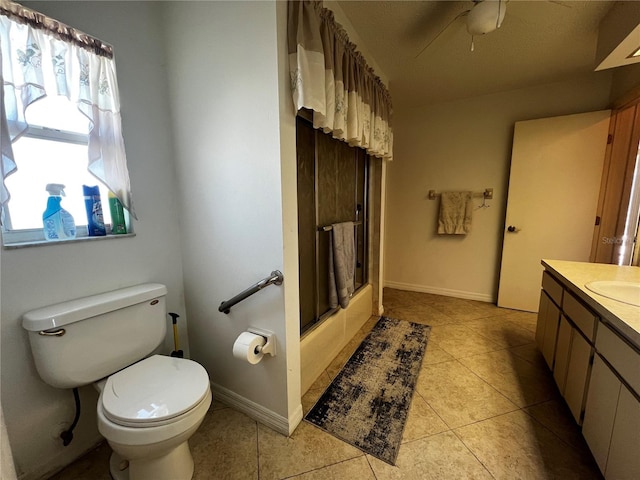 full bathroom featuring vanity, combined bath / shower with glass door, tile patterned flooring, ceiling fan, and toilet