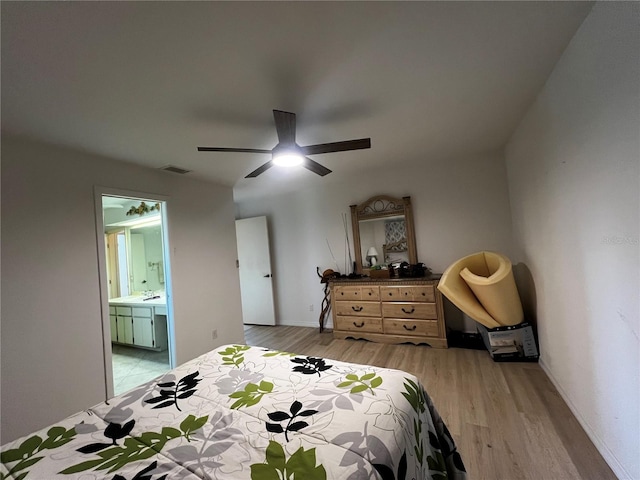 bedroom with connected bathroom, light hardwood / wood-style floors, and ceiling fan