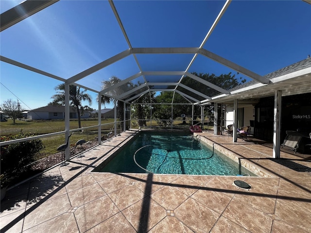 view of pool featuring glass enclosure and a patio area