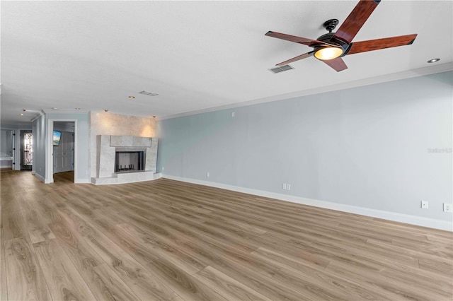 unfurnished living room with light hardwood / wood-style floors, ceiling fan, and crown molding