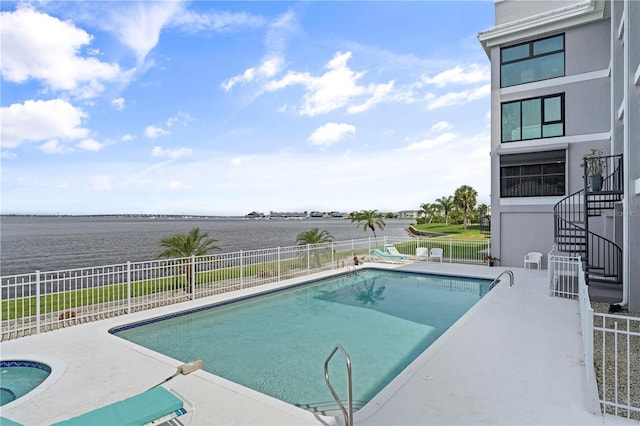 view of swimming pool with a patio and a water view