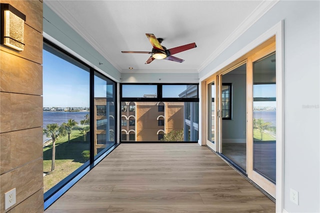 unfurnished sunroom with ceiling fan, french doors, and a water view