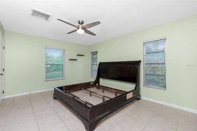 tiled bedroom featuring ceiling fan