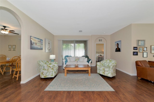 living room featuring ceiling fan and dark hardwood / wood-style flooring