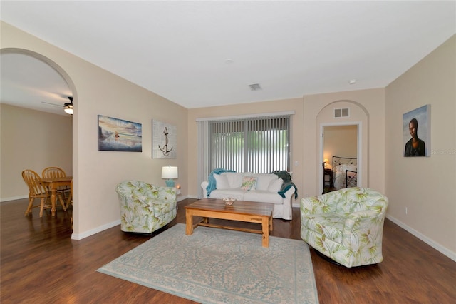 living room with dark hardwood / wood-style flooring and ceiling fan