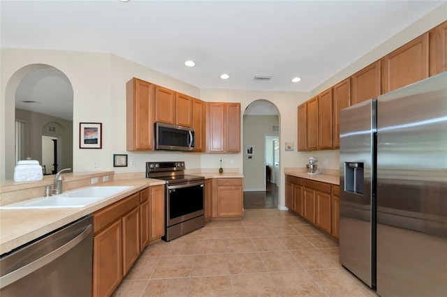 kitchen featuring sink, light tile patterned floors, and stainless steel appliances