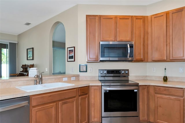 kitchen with sink, kitchen peninsula, and stainless steel appliances