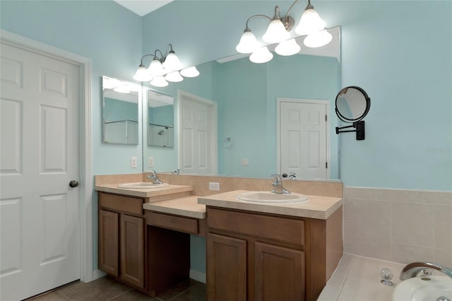 bathroom with tile patterned floors, a tub to relax in, vanity, and a chandelier