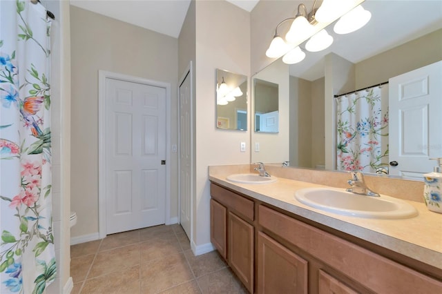 bathroom with tile patterned flooring, vanity, toilet, and a notable chandelier