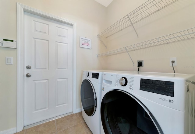 clothes washing area with washing machine and clothes dryer and light tile patterned floors