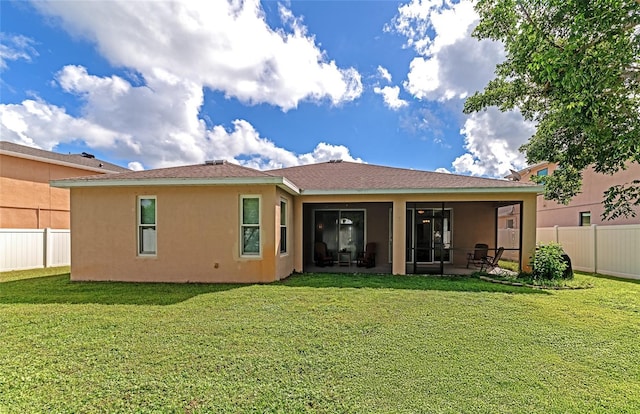 back of property featuring a sunroom and a yard