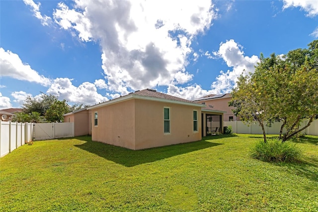 rear view of property with a yard