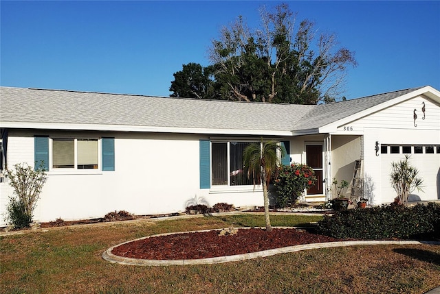 single story home with an attached garage, a front yard, and a shingled roof