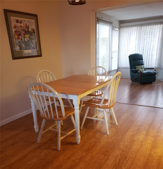 dining area featuring light wood finished floors and baseboards