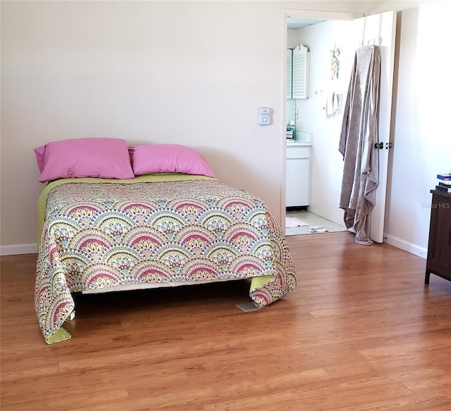 bedroom with light wood-style floors and baseboards