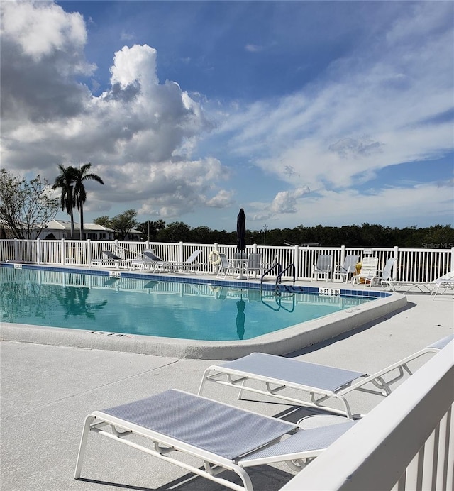 community pool featuring fence and a patio