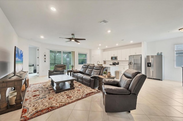 tiled living room with ceiling fan and sink