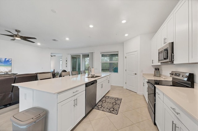 kitchen featuring white cabinetry, a kitchen island with sink, ceiling fan, and appliances with stainless steel finishes