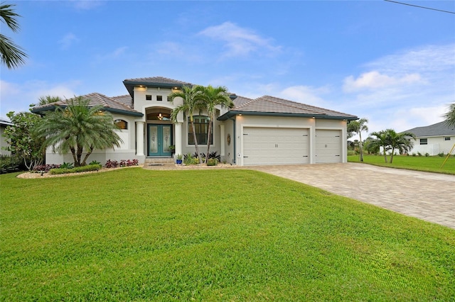 mediterranean / spanish-style home with french doors, a front yard, and a garage