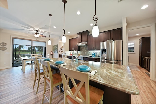 kitchen with sink, ceiling fan, tasteful backsplash, light hardwood / wood-style floors, and stainless steel fridge with ice dispenser