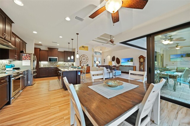 dining space featuring ceiling fan, sink, and light hardwood / wood-style flooring