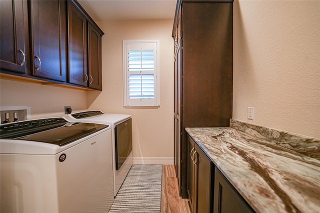 washroom with cabinets, light wood-type flooring, and independent washer and dryer