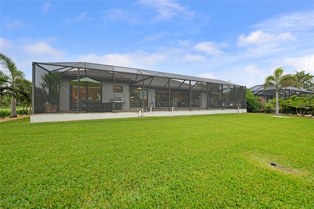 rear view of house with a lanai and a yard