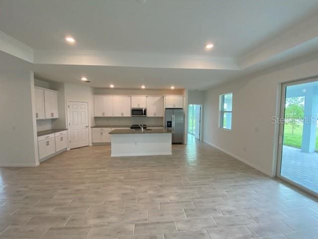 kitchen featuring a center island with sink, white cabinets, and appliances with stainless steel finishes