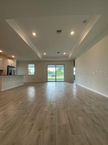 unfurnished room with a tray ceiling and hardwood / wood-style flooring