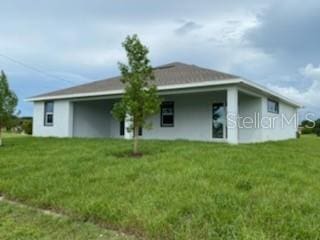 rear view of property with a lawn