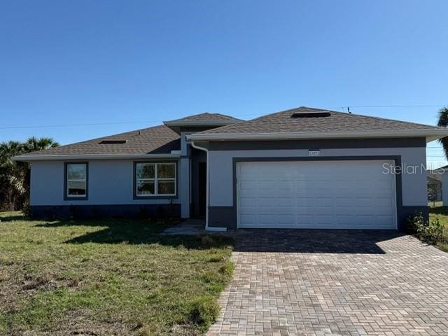 single story home with a front yard and a garage