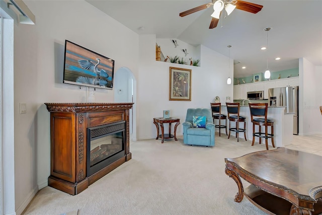 carpeted living room with vaulted ceiling and ceiling fan