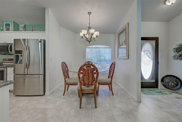 dining area with light tile patterned floors, a healthy amount of sunlight, and a notable chandelier