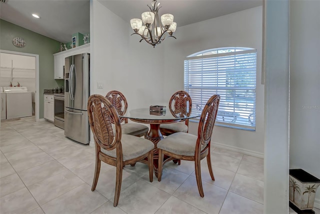 dining area with light tile patterned floors, a chandelier, and lofted ceiling