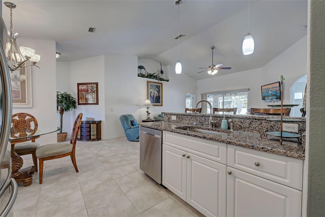 kitchen featuring dark stone counters, vaulted ceiling, sink, dishwasher, and white cabinetry