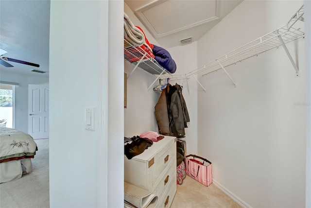 spacious closet featuring light carpet and ceiling fan