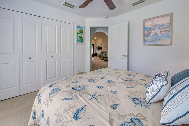 bedroom featuring ceiling fan, light carpet, and a closet