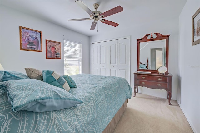 bedroom featuring ceiling fan, a closet, and light colored carpet