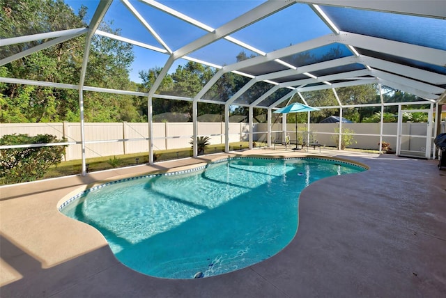 view of pool featuring glass enclosure and a patio