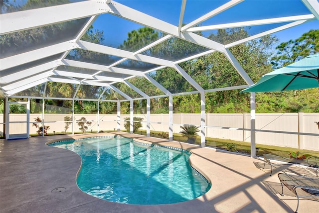 view of swimming pool with glass enclosure and a patio area