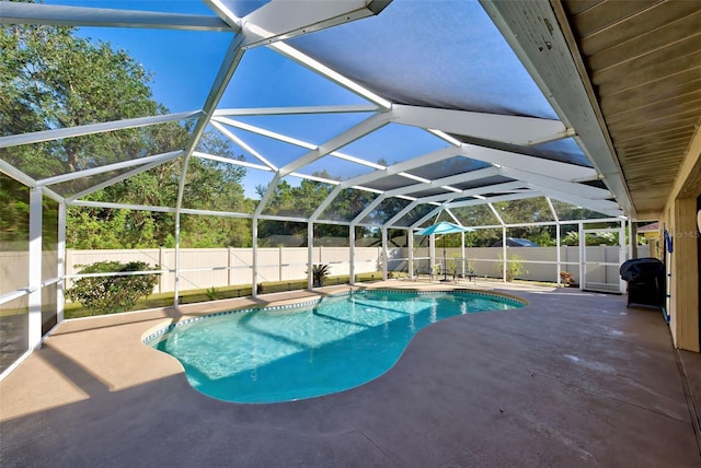 view of swimming pool featuring glass enclosure and a patio