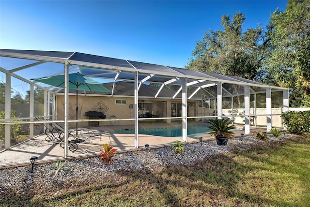 view of swimming pool with glass enclosure and a patio