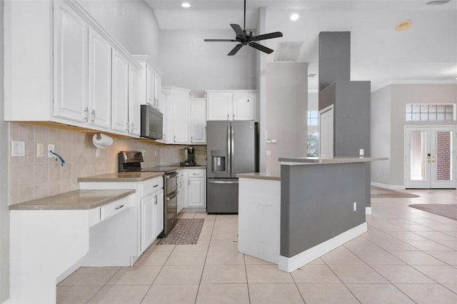 kitchen featuring white cabinets, ceiling fan, light tile patterned flooring, and stainless steel appliances