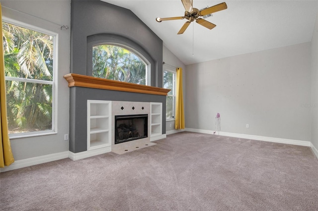 unfurnished living room featuring ceiling fan, a fireplace, carpet floors, and vaulted ceiling